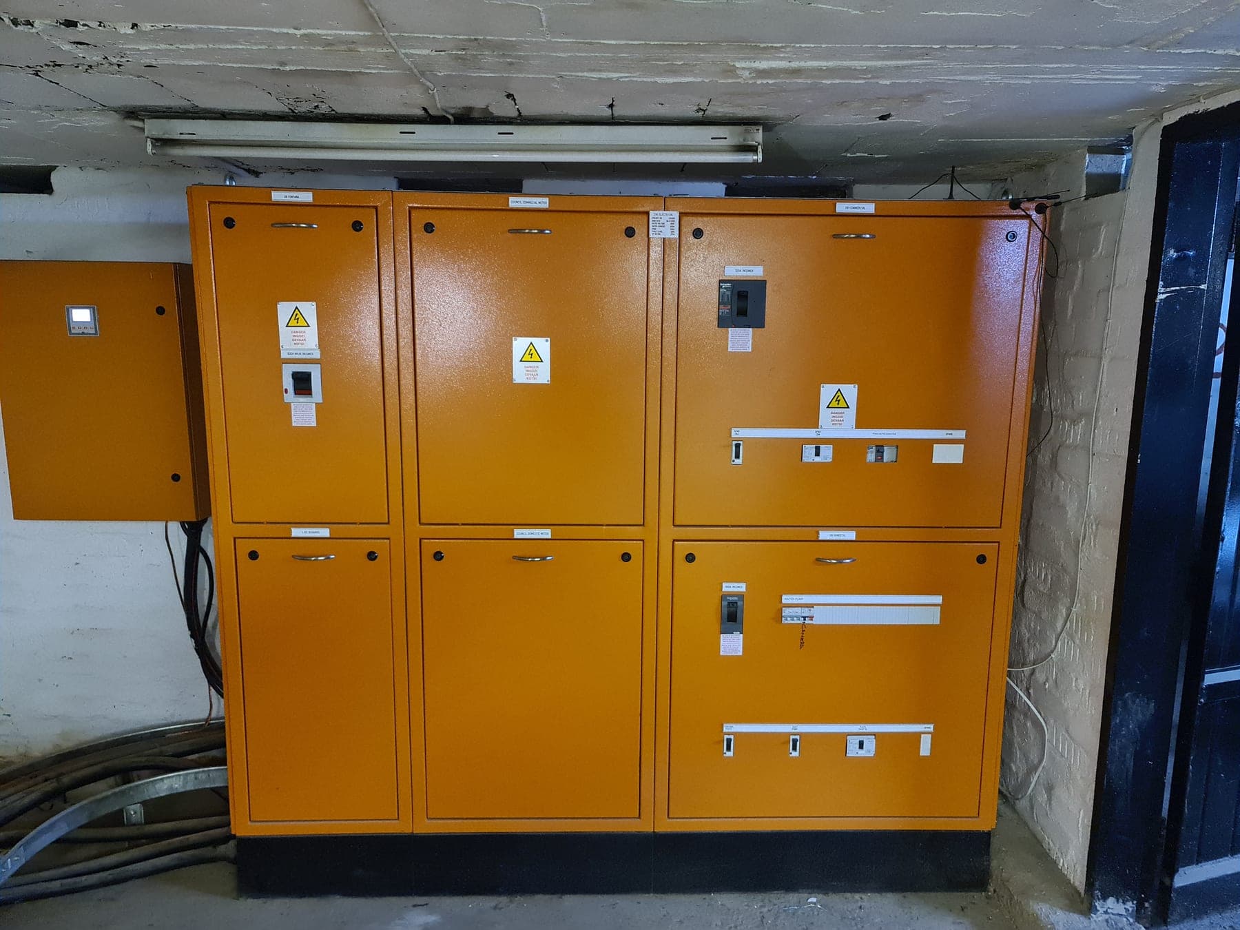 Installed orange commercial distribution boards in a plant room