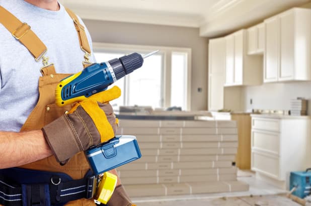 Tradesperson with a drill during a kitchen renovation