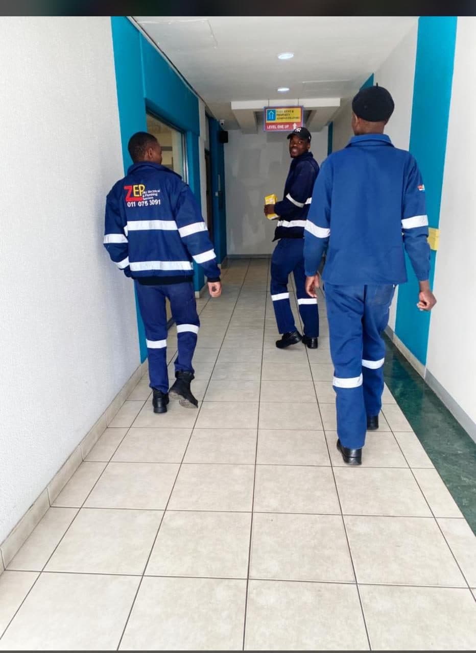 ZEPS technicians in branded navy overalls on a commercial job